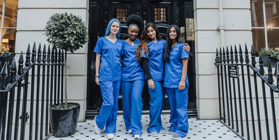 Four nurses in blue scrubs outside a Georgian clinic entrance, Lutronic Genius RF microneedling London